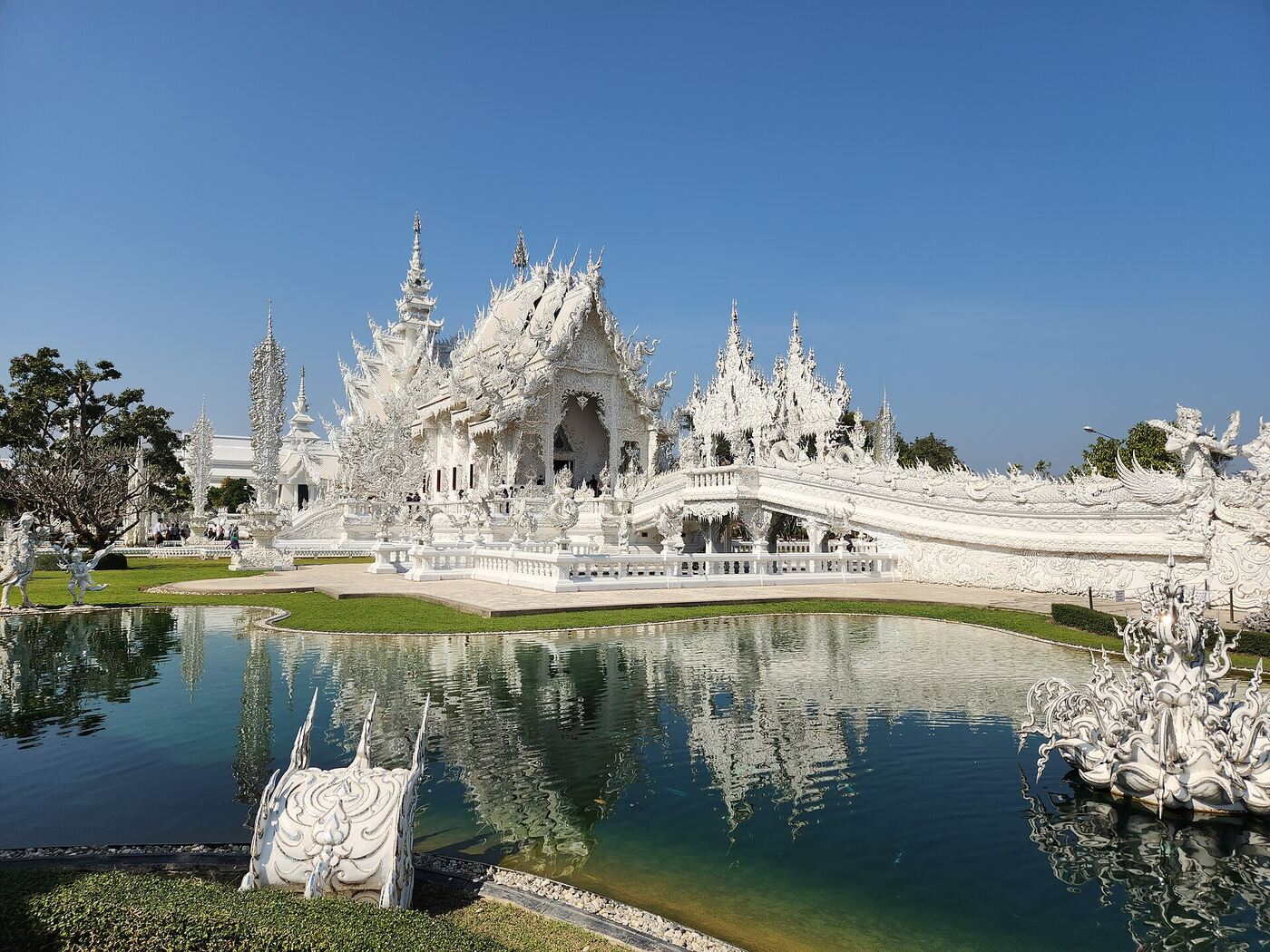 Wat Rong Khun, the White Temple, mirrored in its pond at Chiang Rai
